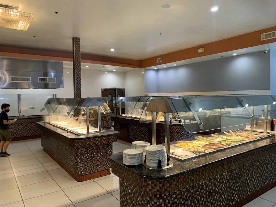 Buffet trays with assorted Chinese dishes.